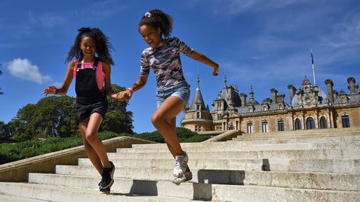 Girls running down the steps in the garden at Waddesdon Manor, Buckinghamshire